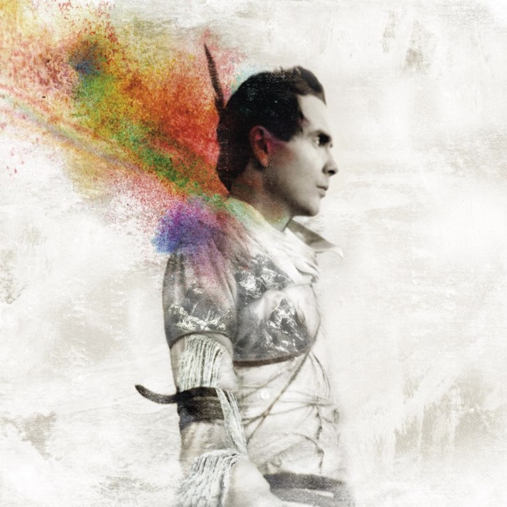 Profile portrait of Jónsi with colorful pixelated light effects emanating from his head.