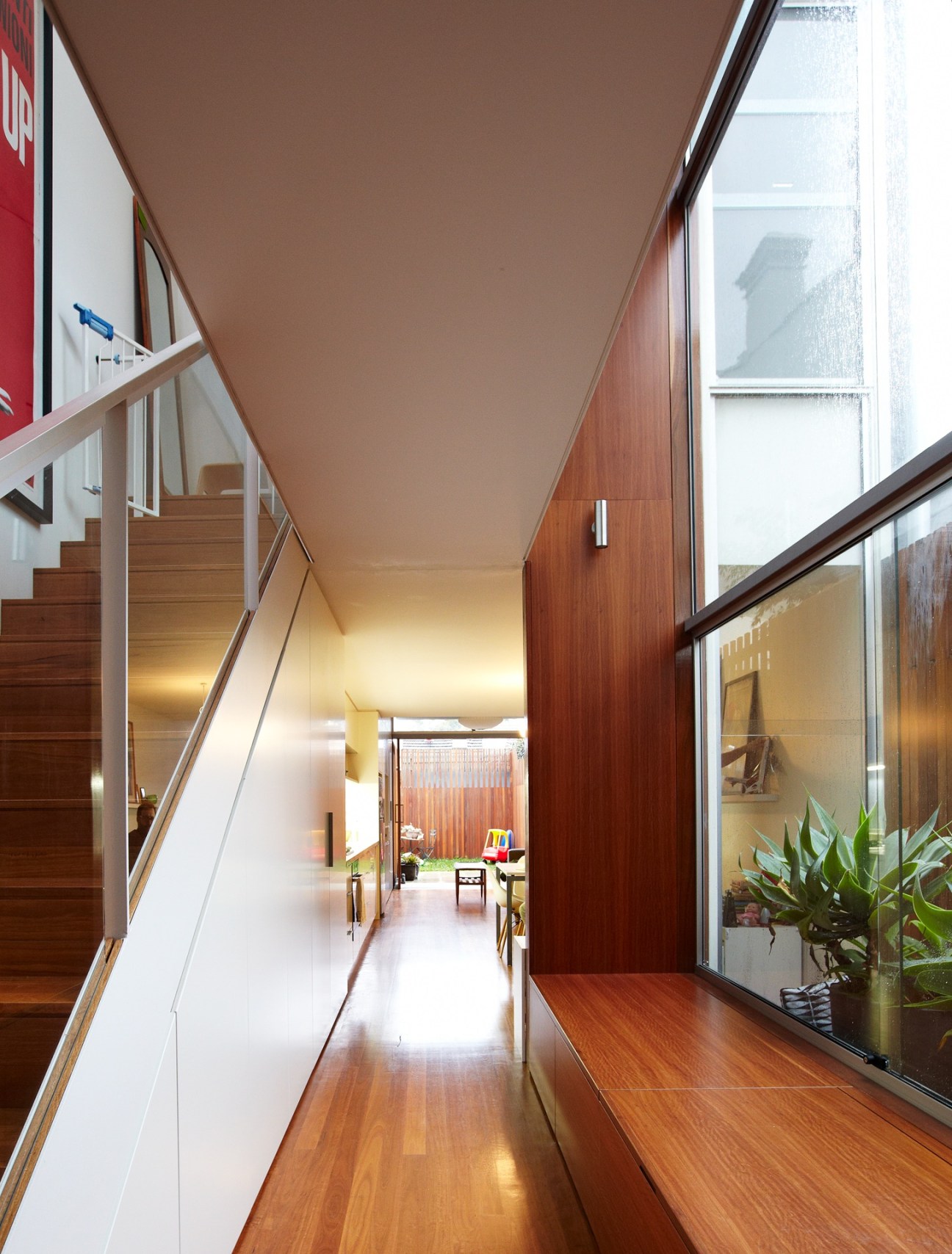 Modern interior hallway with wooden flooring, stairs, and contemporary finishes in a renovated Erskineville home.