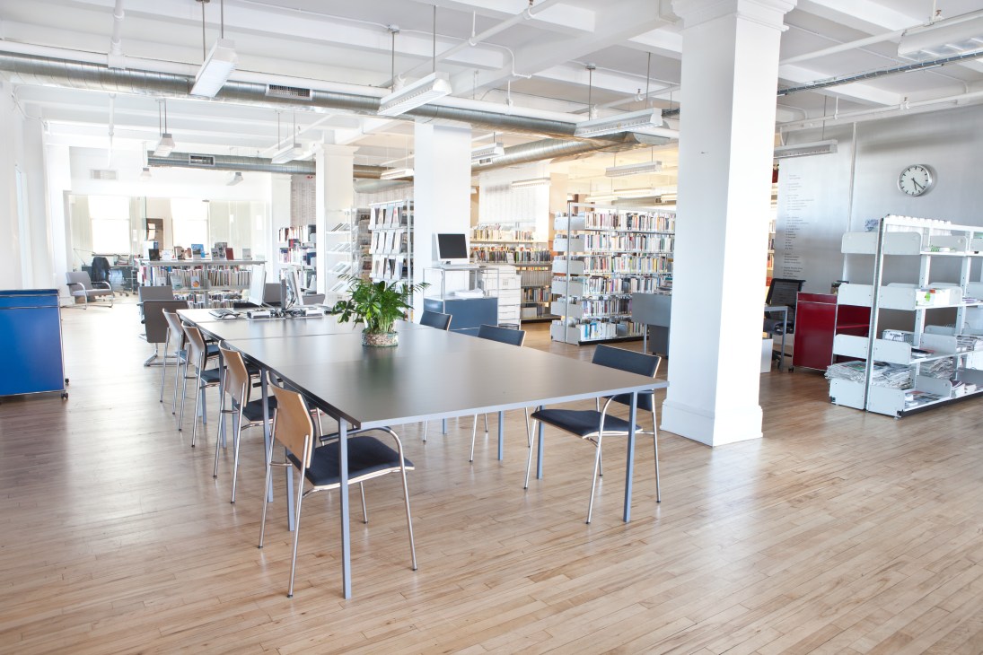 Modern library workspace with tables, chairs, bookshelves, and natural light at Goethe-Institut New York.