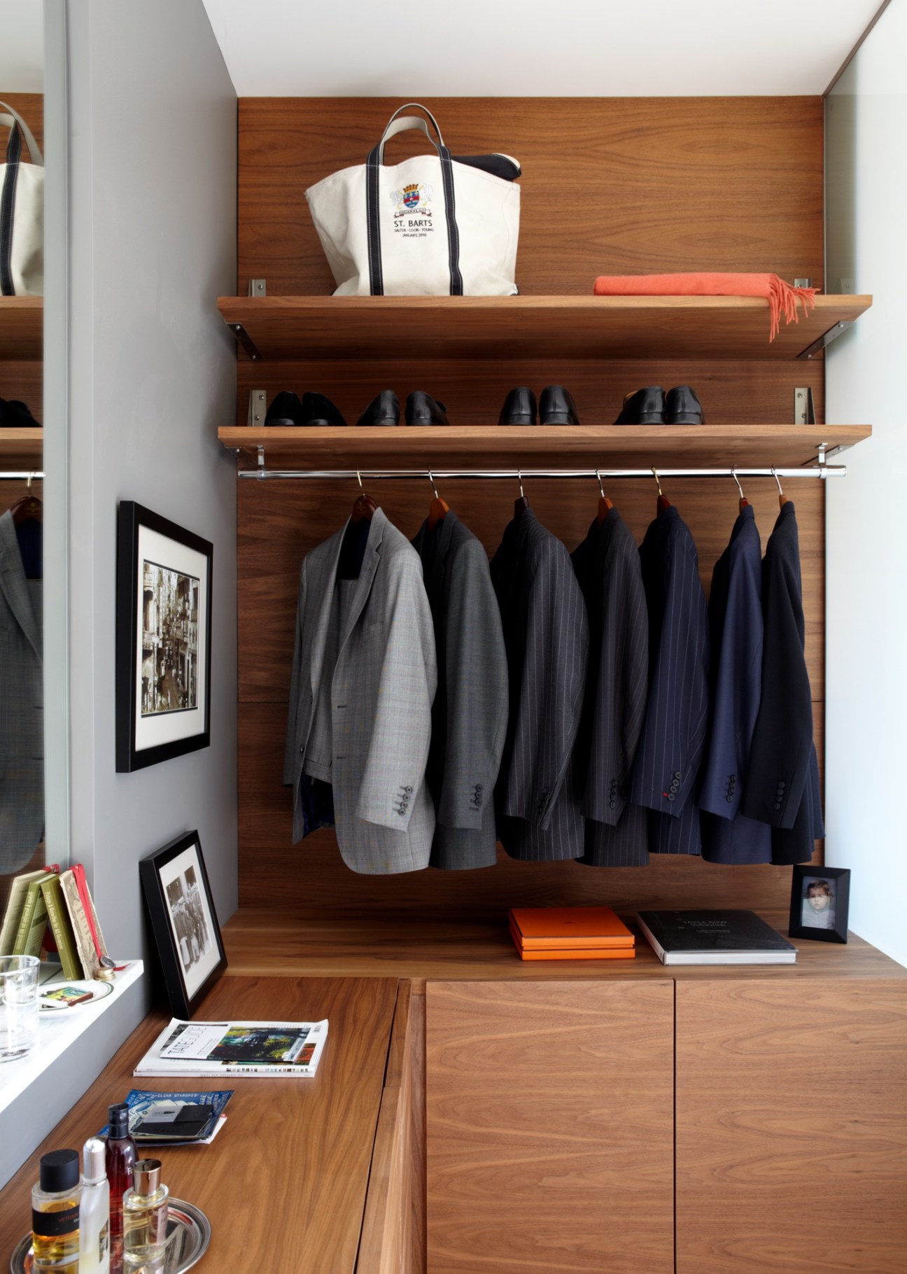 Modern wooden closet with shelving displaying suits, shoes, and accessories in a Fort Point loft apartment.