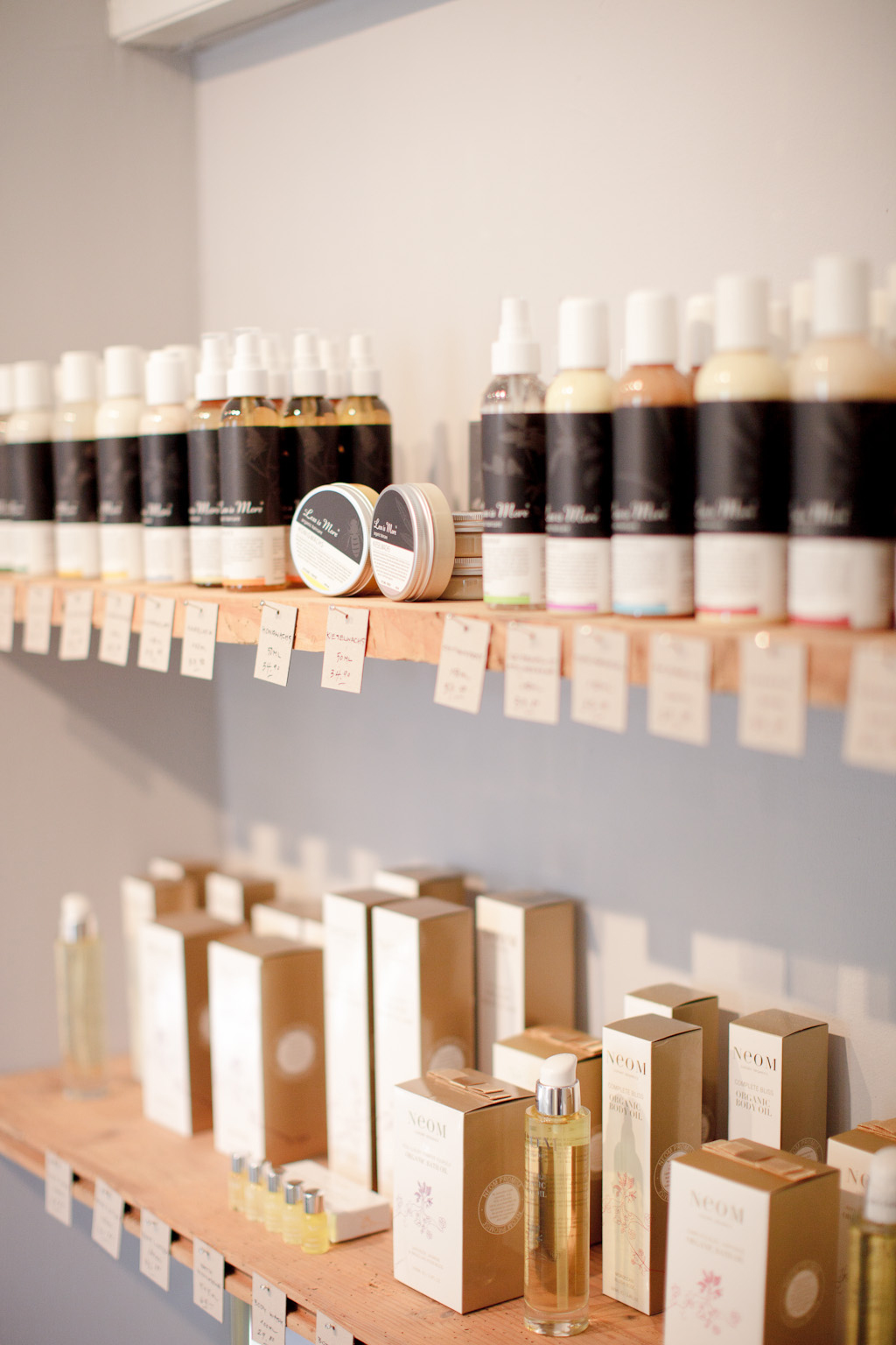 Display shelf at N°2 boutique featuring cosmetic products and fragrances in glass bottles and boxes.
