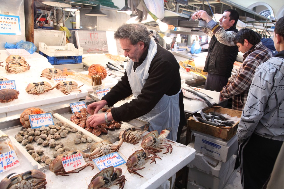 Fishmonger Dimitra Arapi arranging crabs and shellfish at his market stall in Athens.