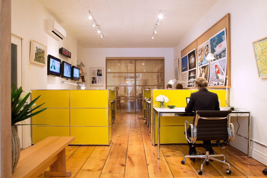 Interior of Monocle's Toronto bureau with bright yellow USM Haller modular furniture and wooden flooring.