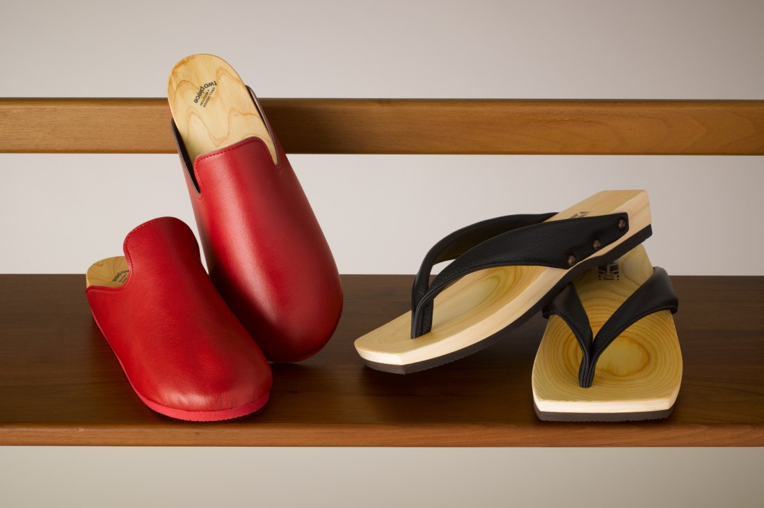 Mizutori Kogyo traditional Japanese geta slippers with red leather straps and wooden soles displayed on a wooden shelf.