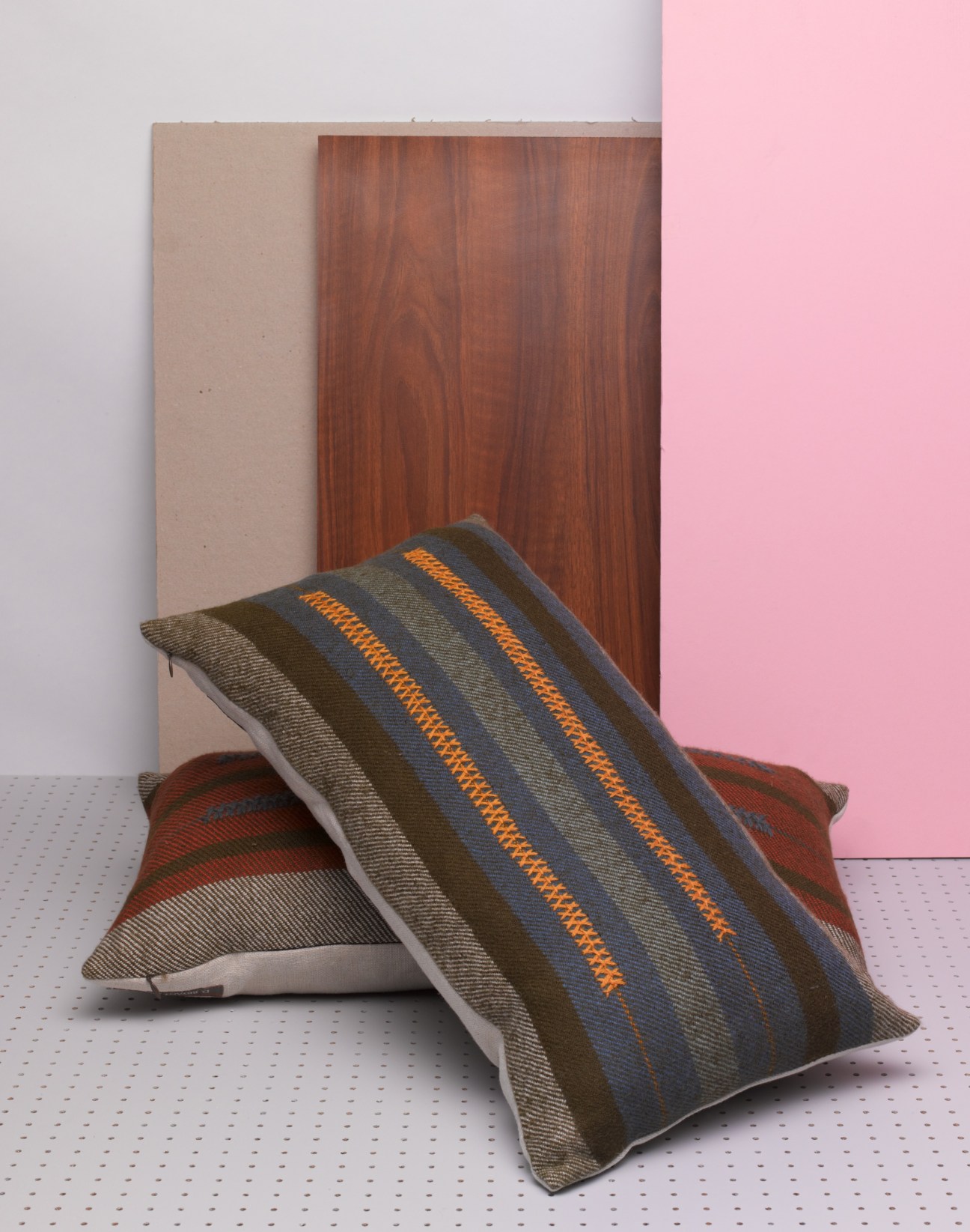 Hand-woven baby alpaca pillows with linen backing and hand embroidery from D Bryant Archie, featuring striped patterns in earth tones and orange.