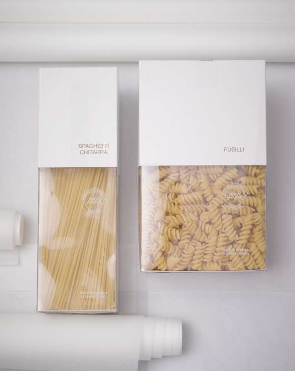 Two boxes of Mancini pasta with elegant white packaging showing spaghetti chitarra and fusilli varieties.