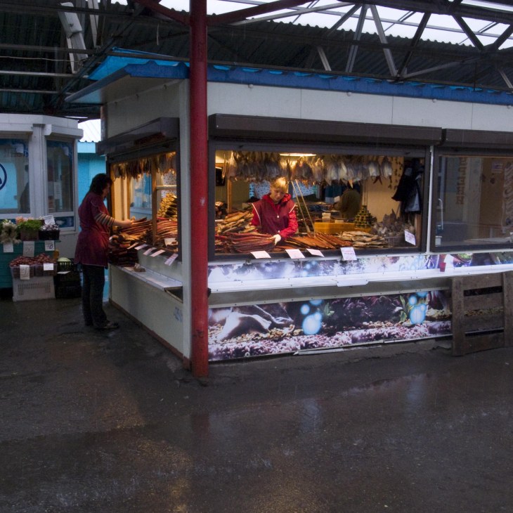 Market stall displaying dried fish and seafood products with vendors inside, Petropavlovsk