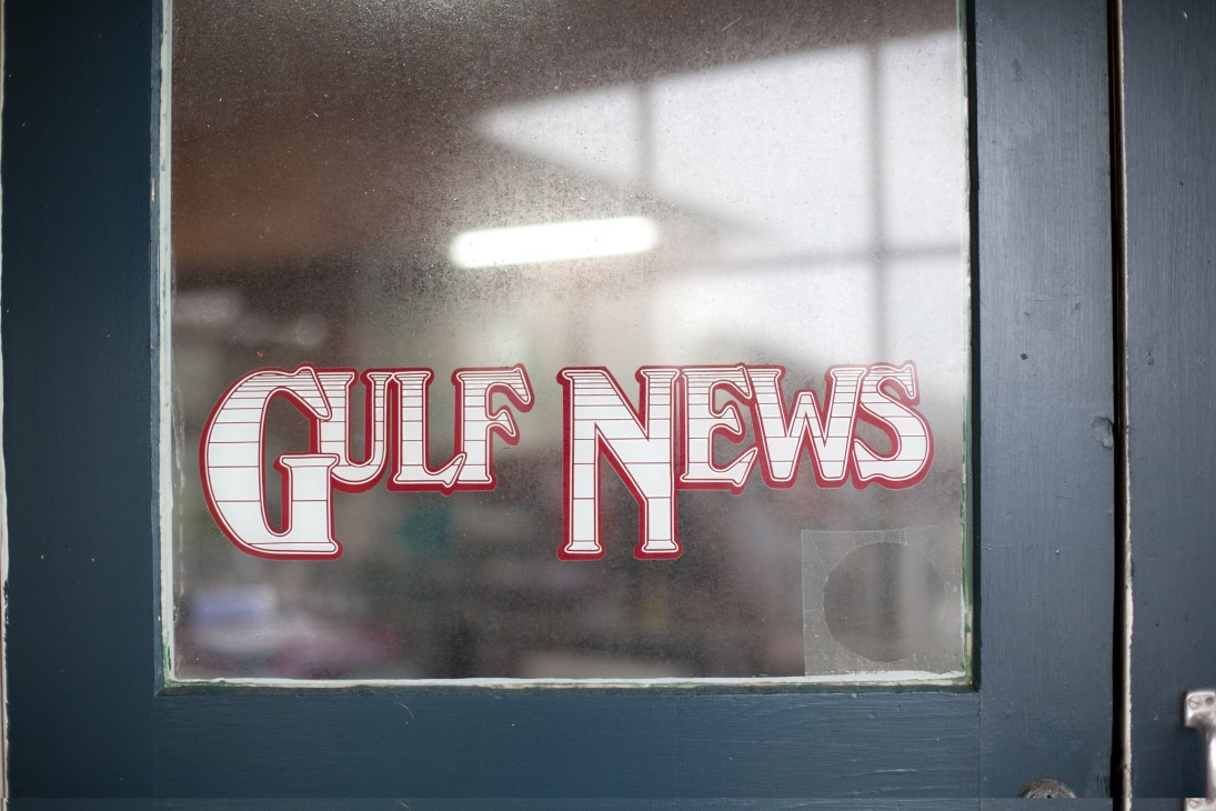 Gulf News logo in red text on a window.