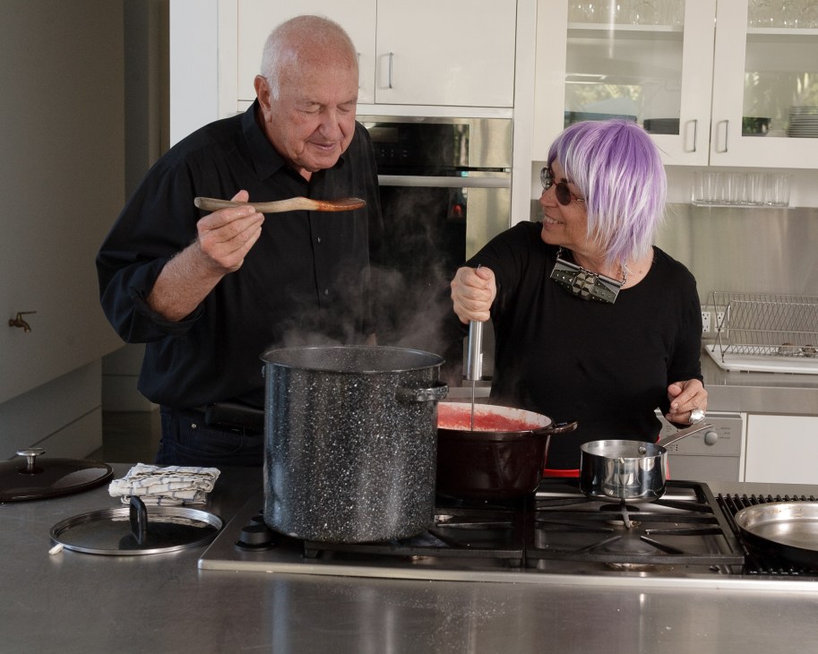 Don and Mera Rubell taste cooking pasta sauce together in their kitchen.