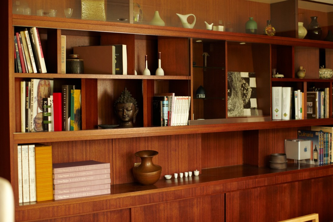 Wooden shelving unit displaying books, ceramics, and decorative objects in Simplicity's Tokyo office.