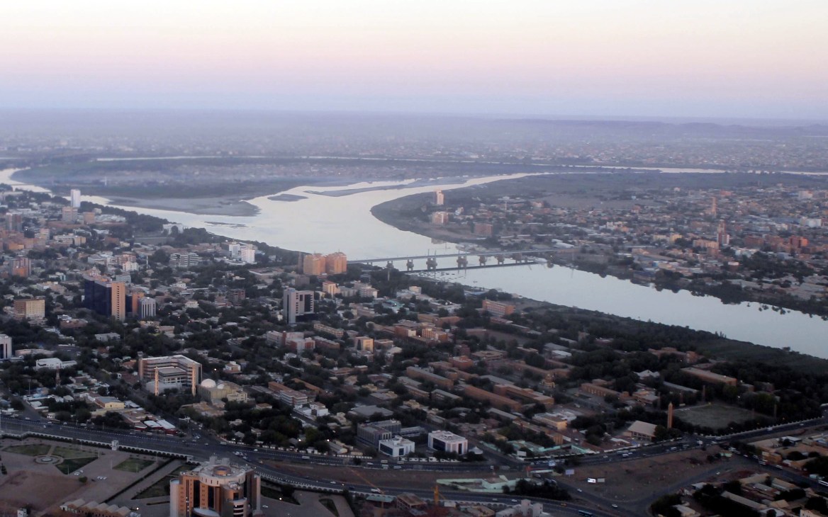 Aerial view of the Nile River winding through a sprawling cityscape with residential buildings and infrastructure.