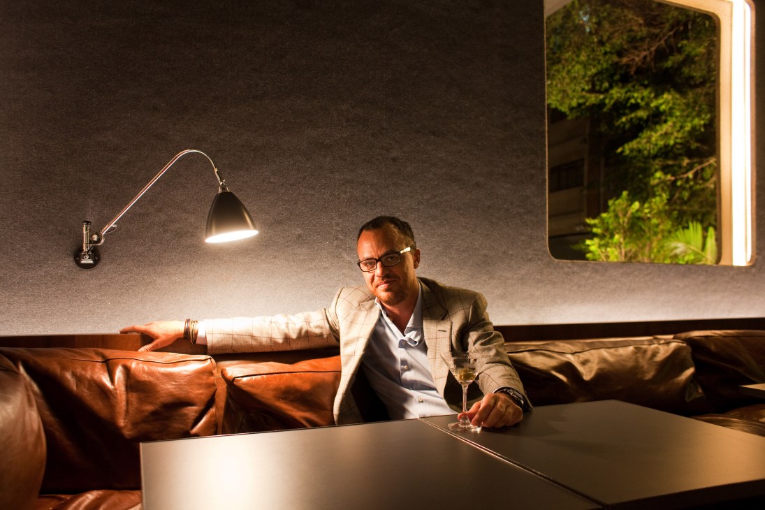 Marcos Campos, owner of Numero nightclub in São Paulo, relaxes on a leather sofa with a drink.