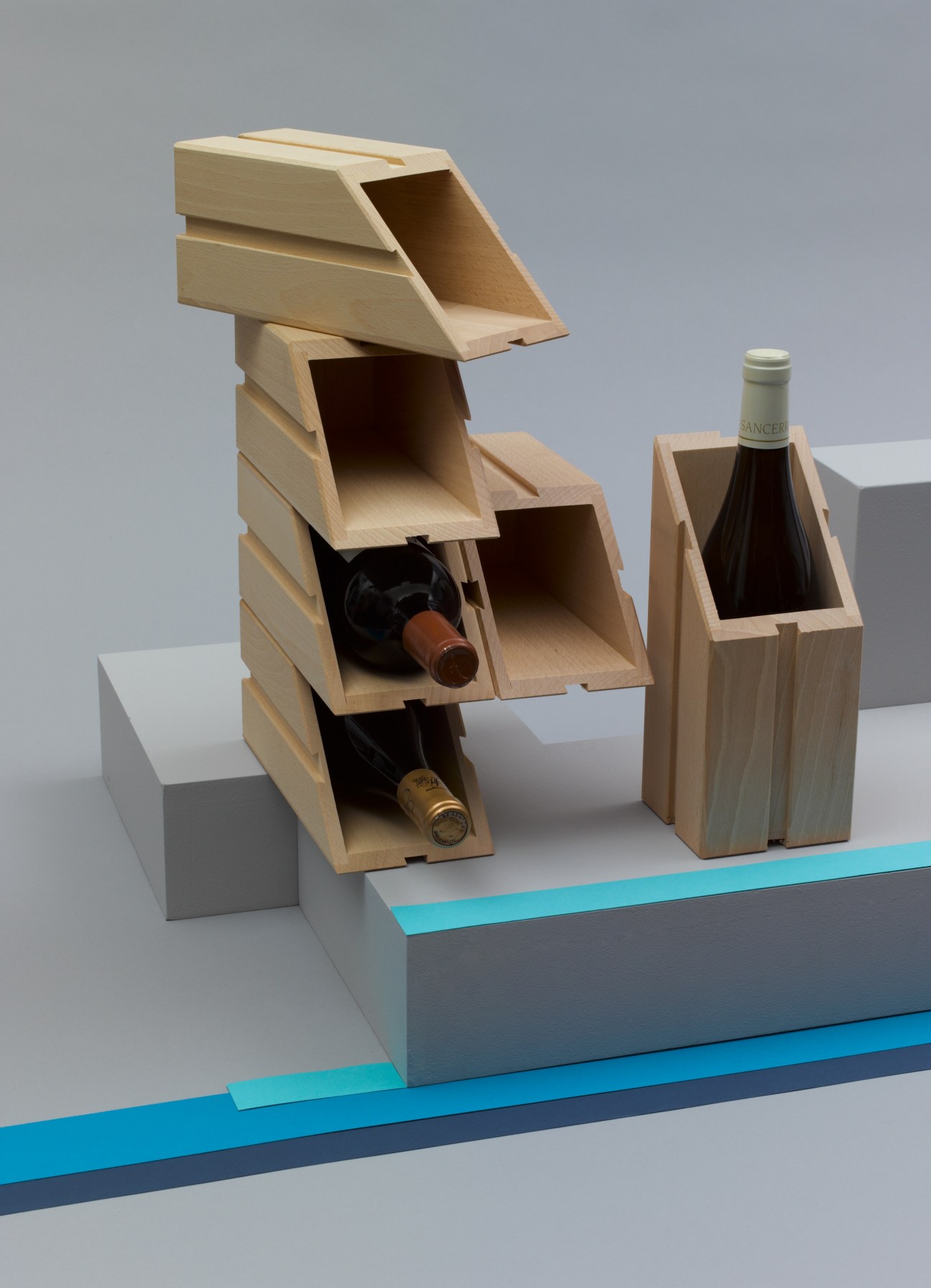 Modular beech wood wine bottle holder by Ci/stà with stacked compartments holding bottles.
