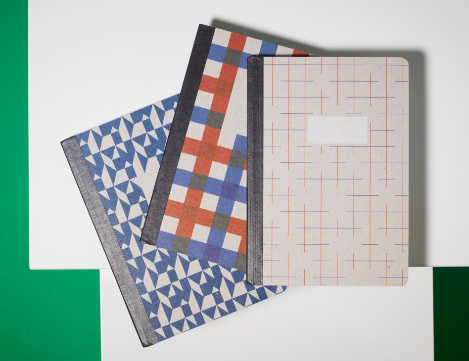 Papier Tigre linen-bound notebooks with patterned covers displayed open and closed.