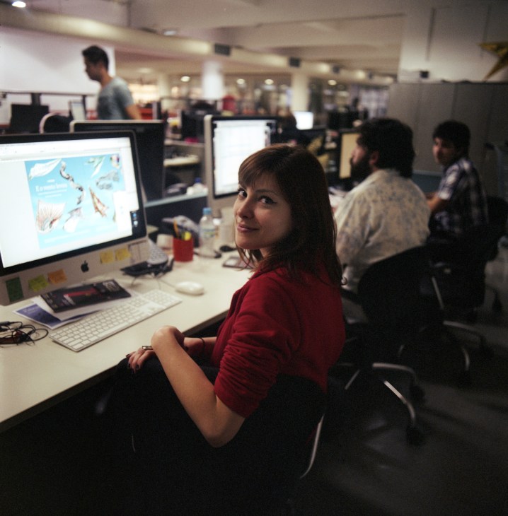 Designer Ana Beatriz de Castro sits at her desk in the Folha de S.Paulo newsroom.