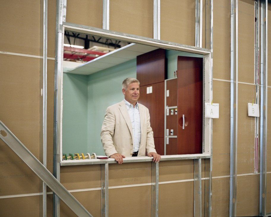 Brian Walker, CEO of Herman Miller, standing in a modernist cabinet display