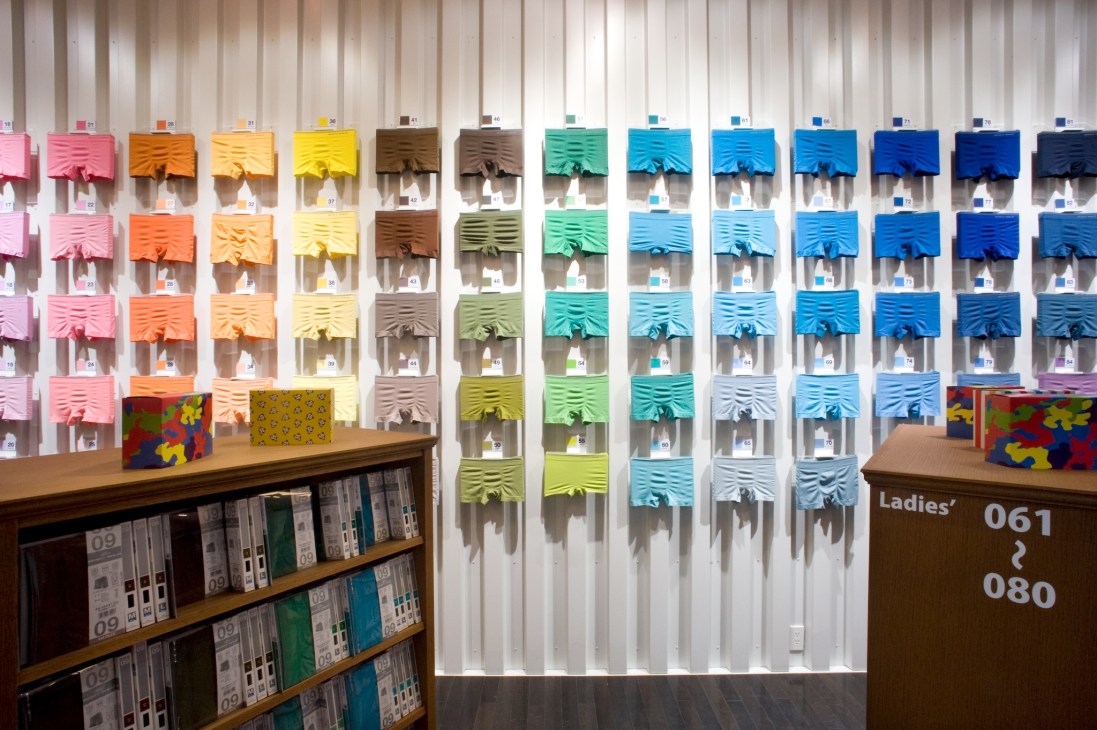 Gunze flagship store display wall with colorful underwear samples arranged in rows.