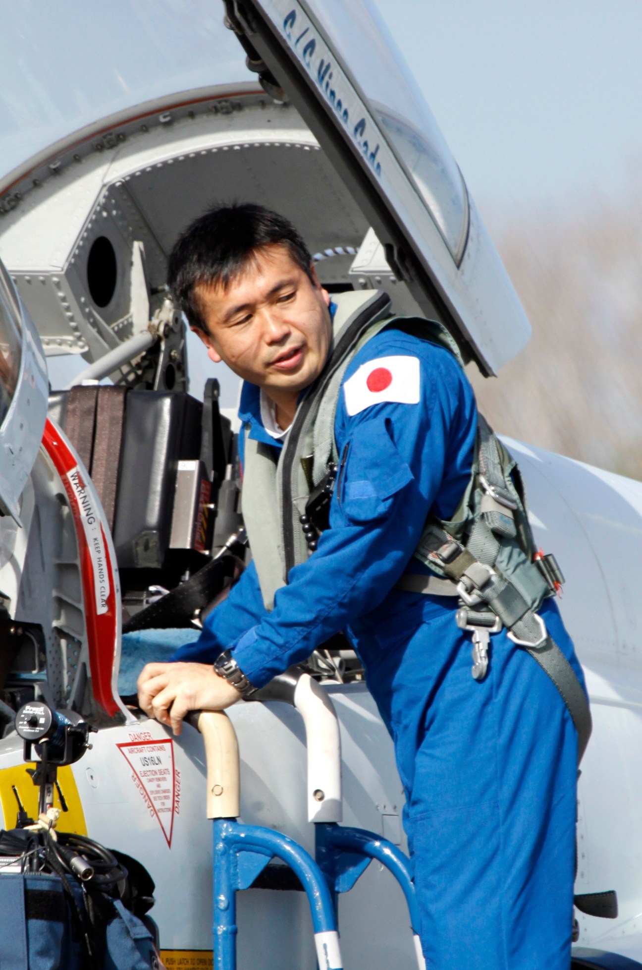 Japanese astronaut Koichi Wakata in blue flight suit entering spacecraft at Kennedy Space Center.