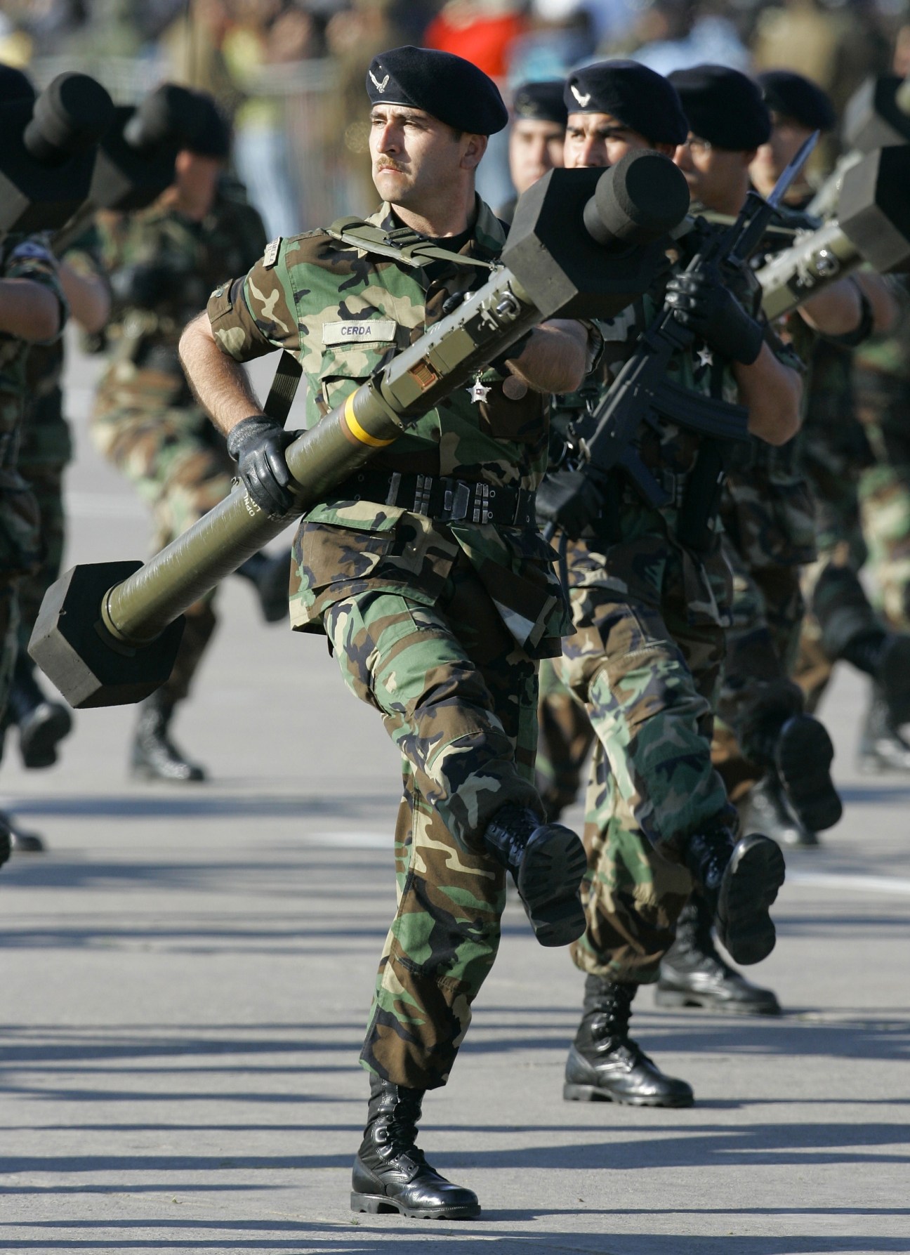 Chilean soldier in camouflage uniform carrying a rocket launcher during military parade.