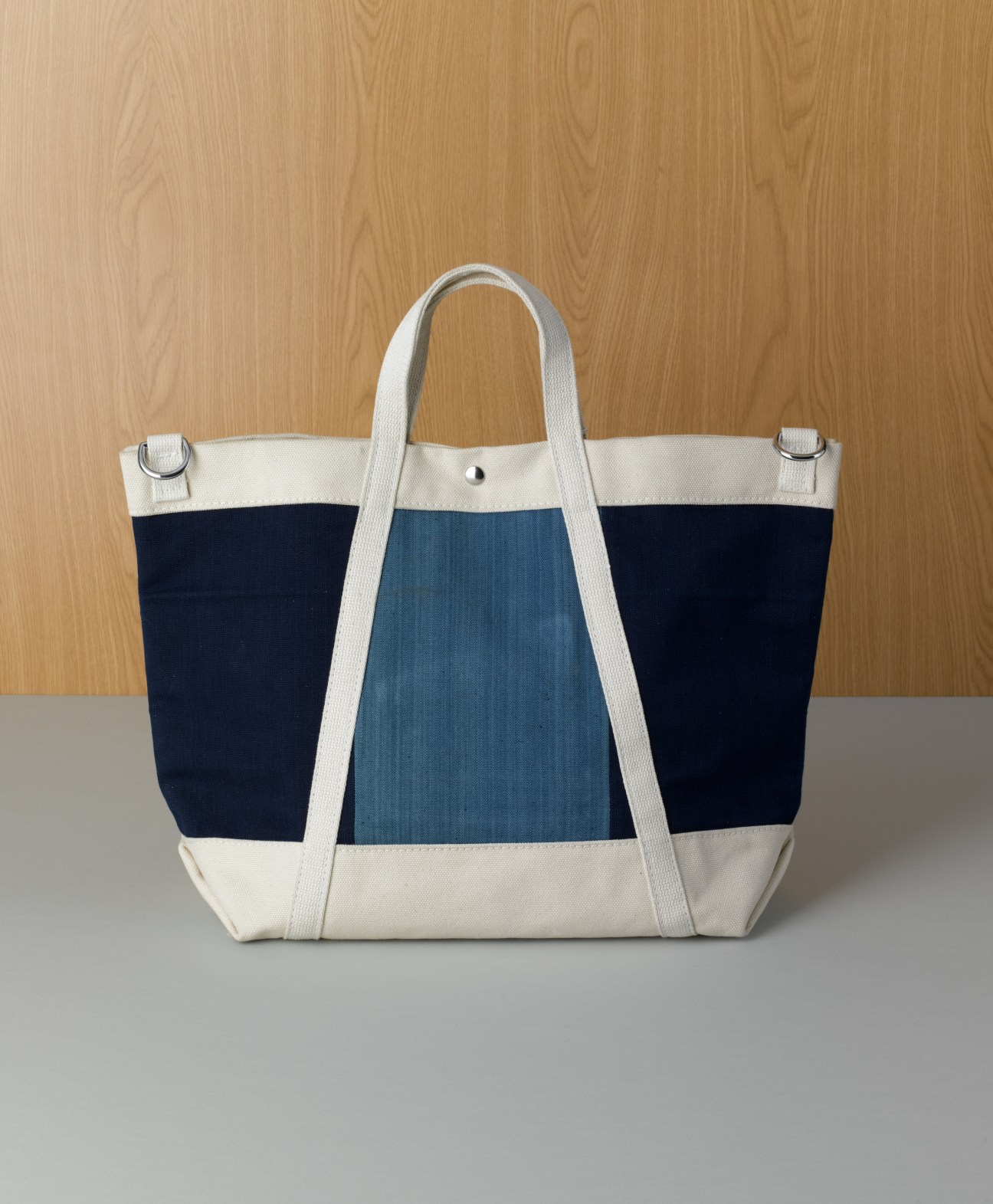Yuketen tote bag with navy, cream and indigo Japanese Kasuri cloth stripes and white handles.