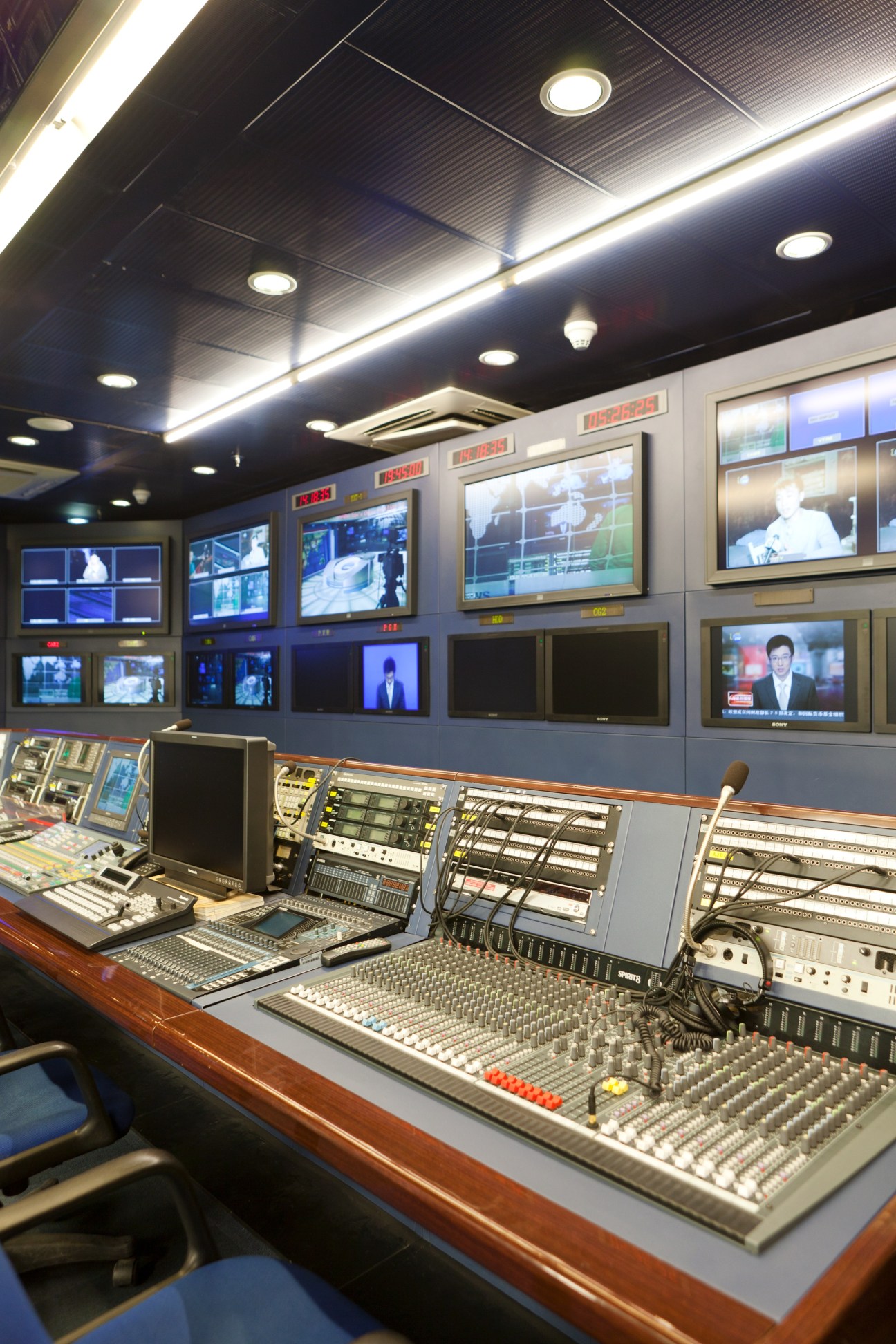 CNC World control room with multiple monitors displaying news feeds and broadcast equipment.