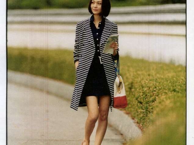 Woman wearing Christian Dior coat and Fendi dress walking through Ohori Park in Fukuoka.