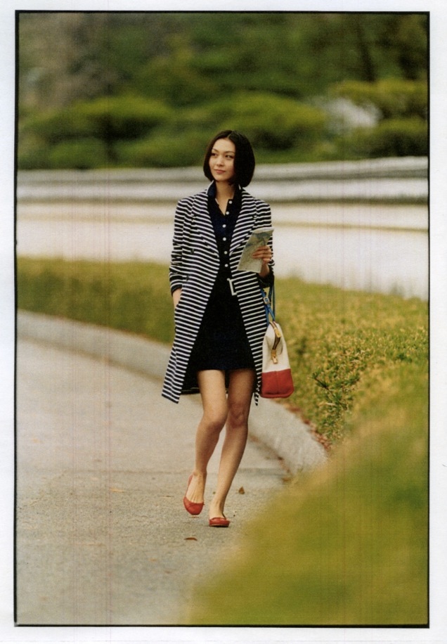 Woman wearing Christian Dior coat and Fendi dress walking through Ohori Park in Fukuoka.