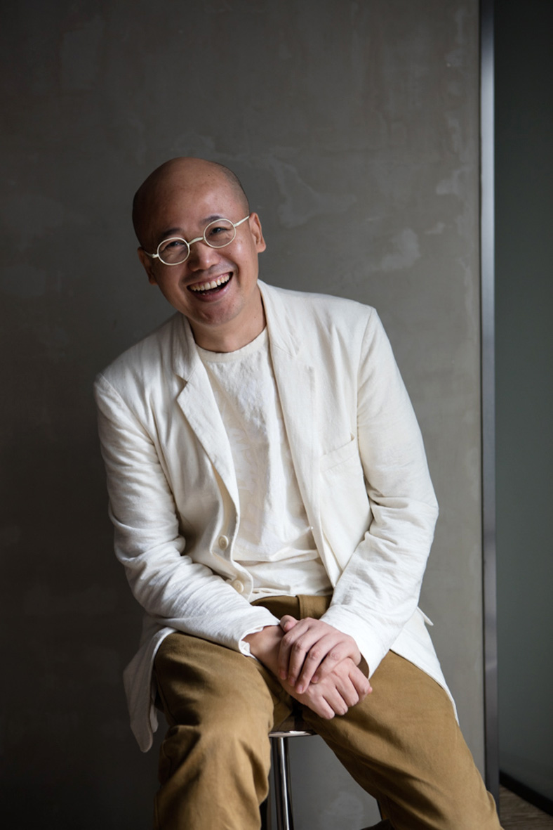 Portrait of Mao Jihong, founder of Fang Suo Commune bookshop chain, wearing glasses and cream blazer.