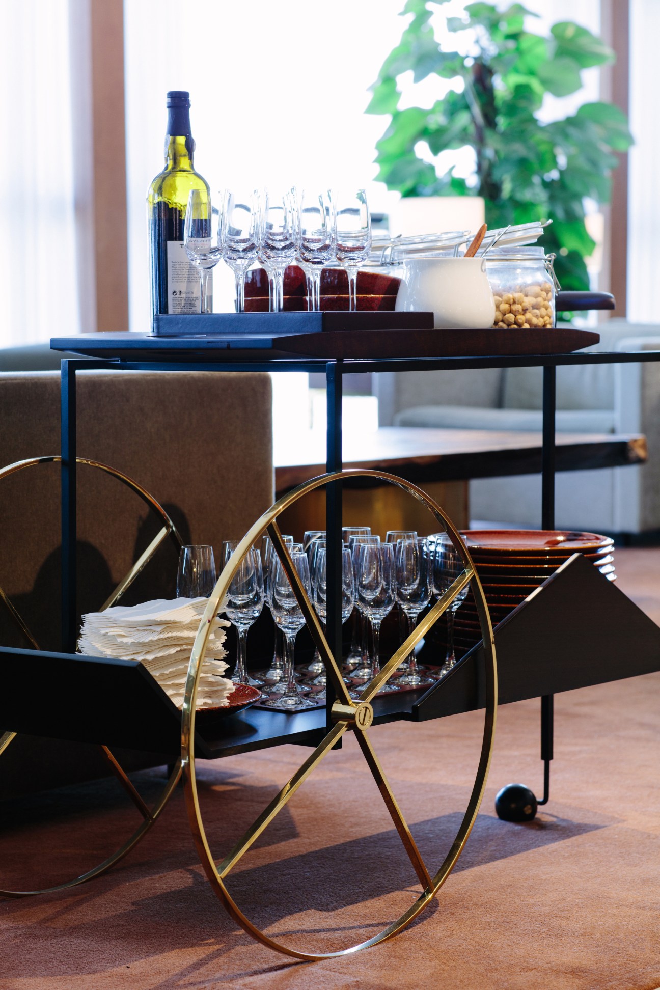 Cathay Pacific first-class lounge interior with wine glasses, bottle, and bar service setup.