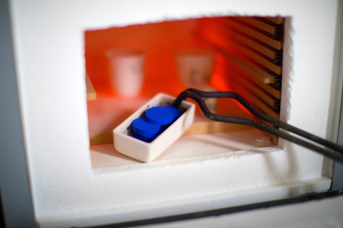 Blue YInMn pigment pellets emerging from a high-temperature furnace.