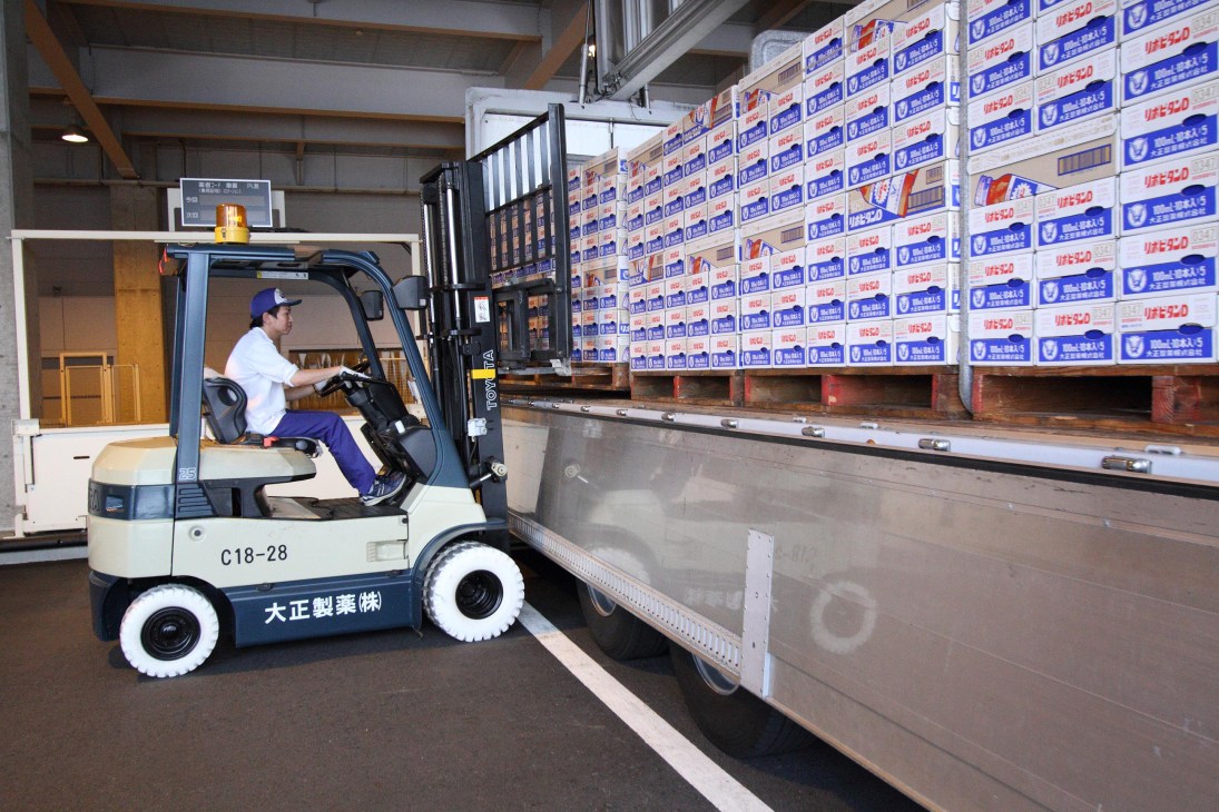 A forklift operator loads boxes of nutrition drinks onto a truck at Taisho Pharmaceutical Co's facility.