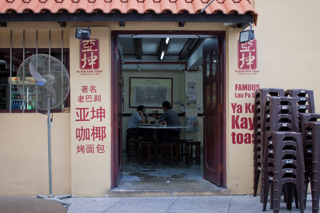 Ya Kun Kaya Toast storefront on China Street with Chinese signage and customers seated inside.