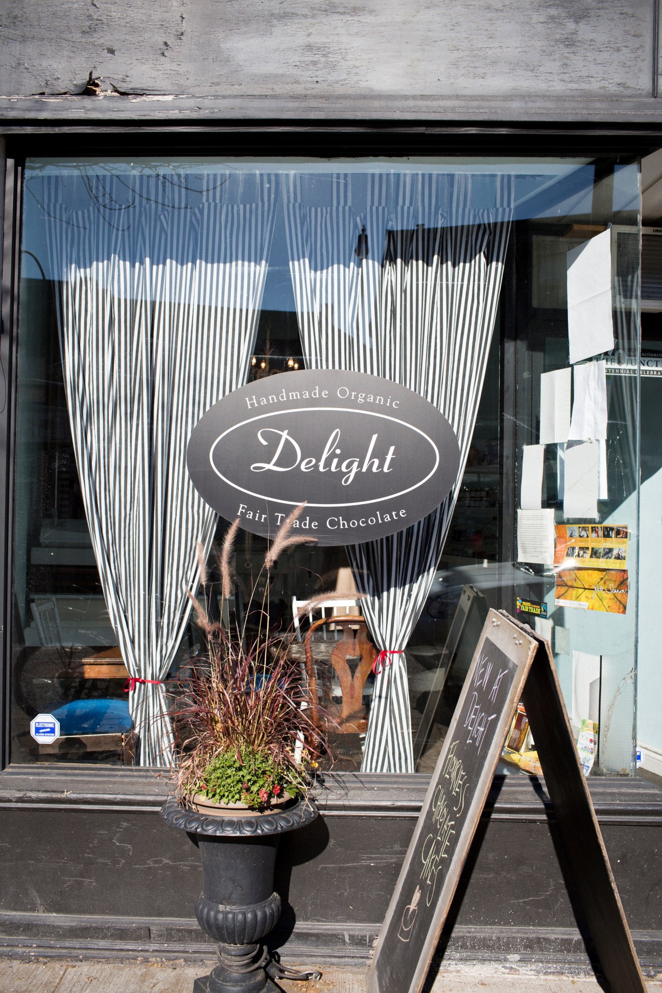 Delight chocolate shop storefront with striped white curtains and handmade organic fair trade chocolate signage.