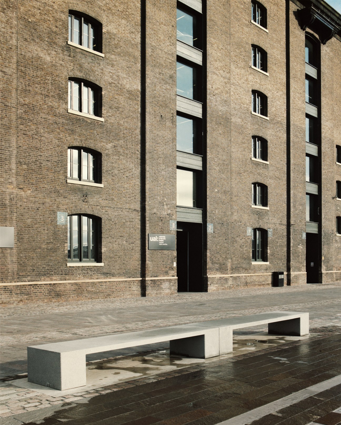Victorian red-brick building facade with arched windows and modern black entrance doors.