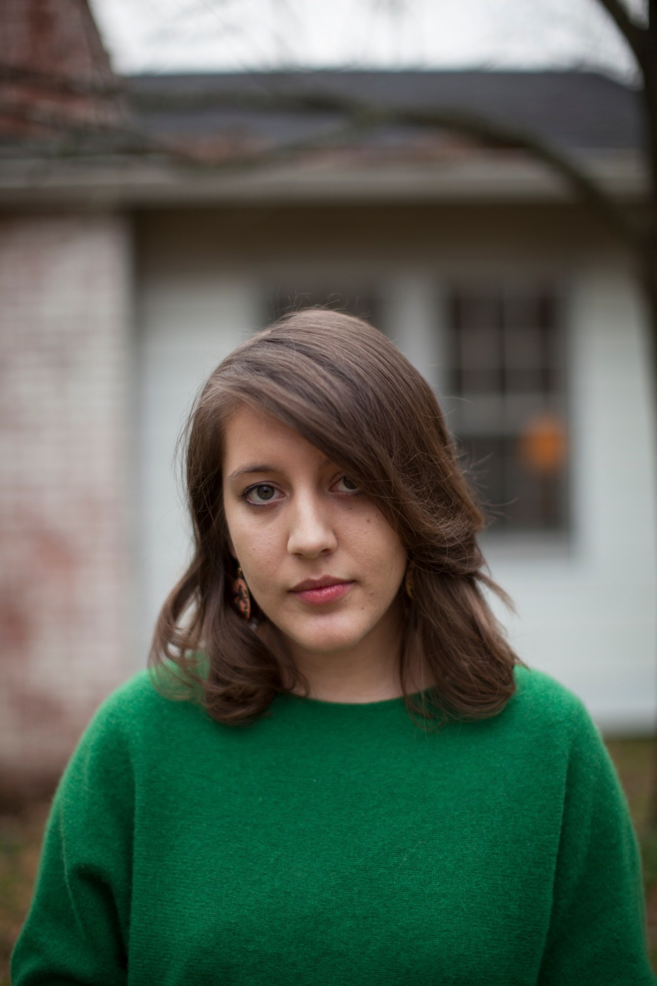 Portrait of Caitlin Rose, Nashville-based singer-songwriter, wearing a green sweater.