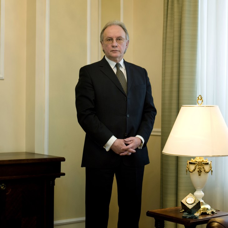 Sergei Martynov, Belarus's foreign minister, standing in a formal office setting wearing a dark suit and glasses.