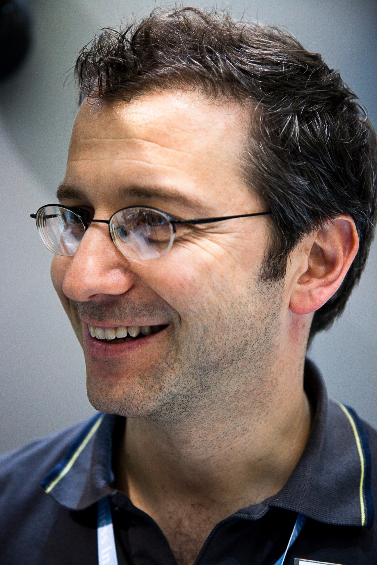 Luca Ceccaroni of Technogym smiles in profile wearing glasses and dark polo shirt.