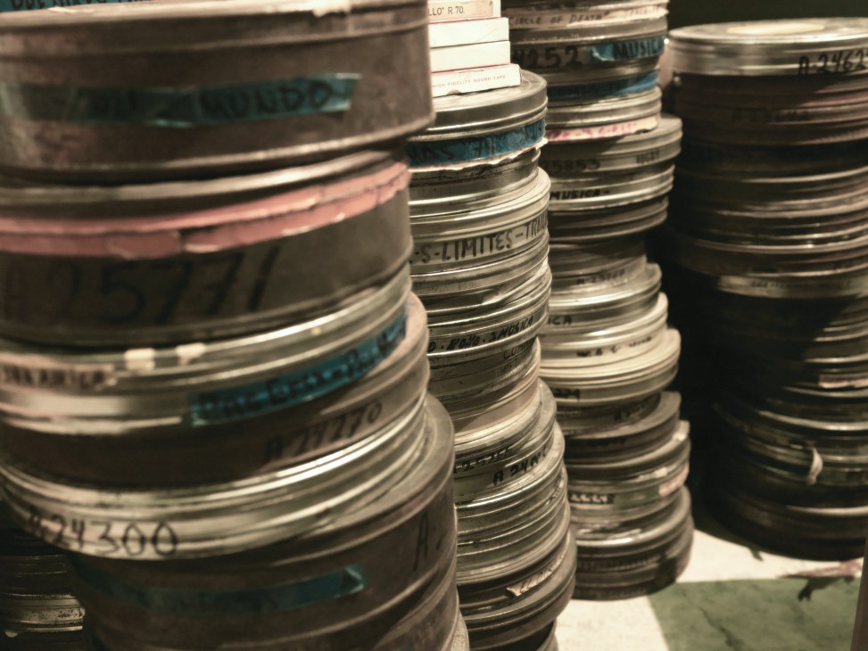 Stacked vintage film reels with labeled bands at Estudios Churubusco archive.