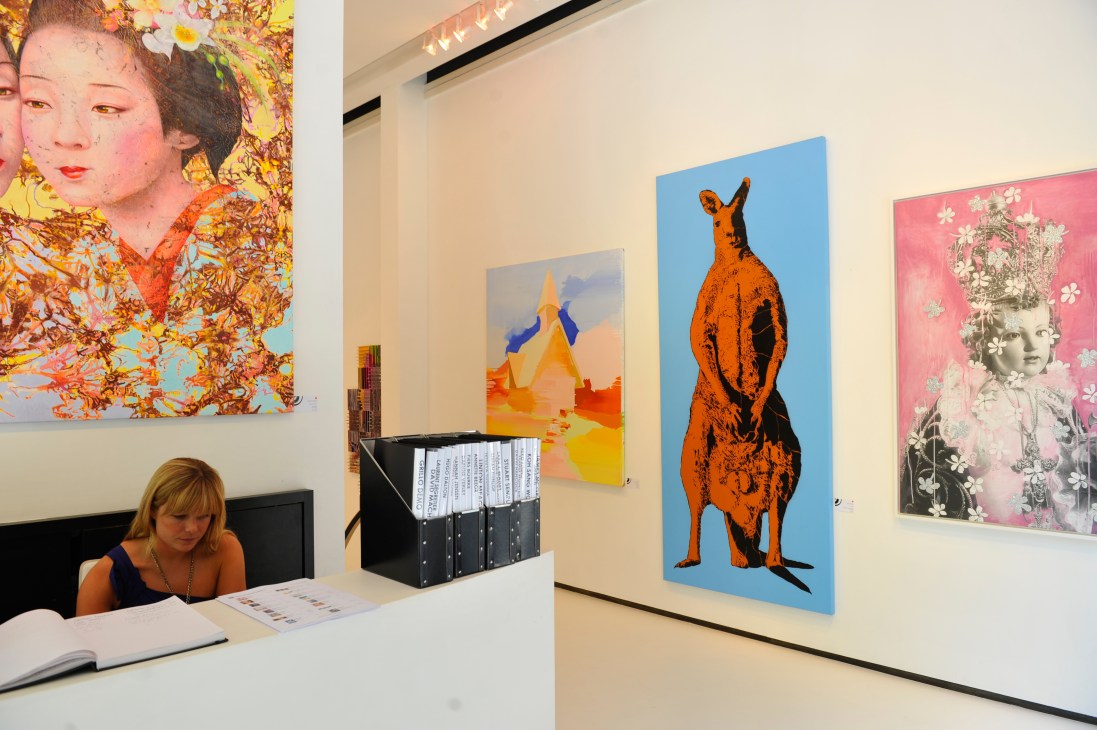 Interior of Cat Street Gallery with modern pop art on white walls and receptionist at desk