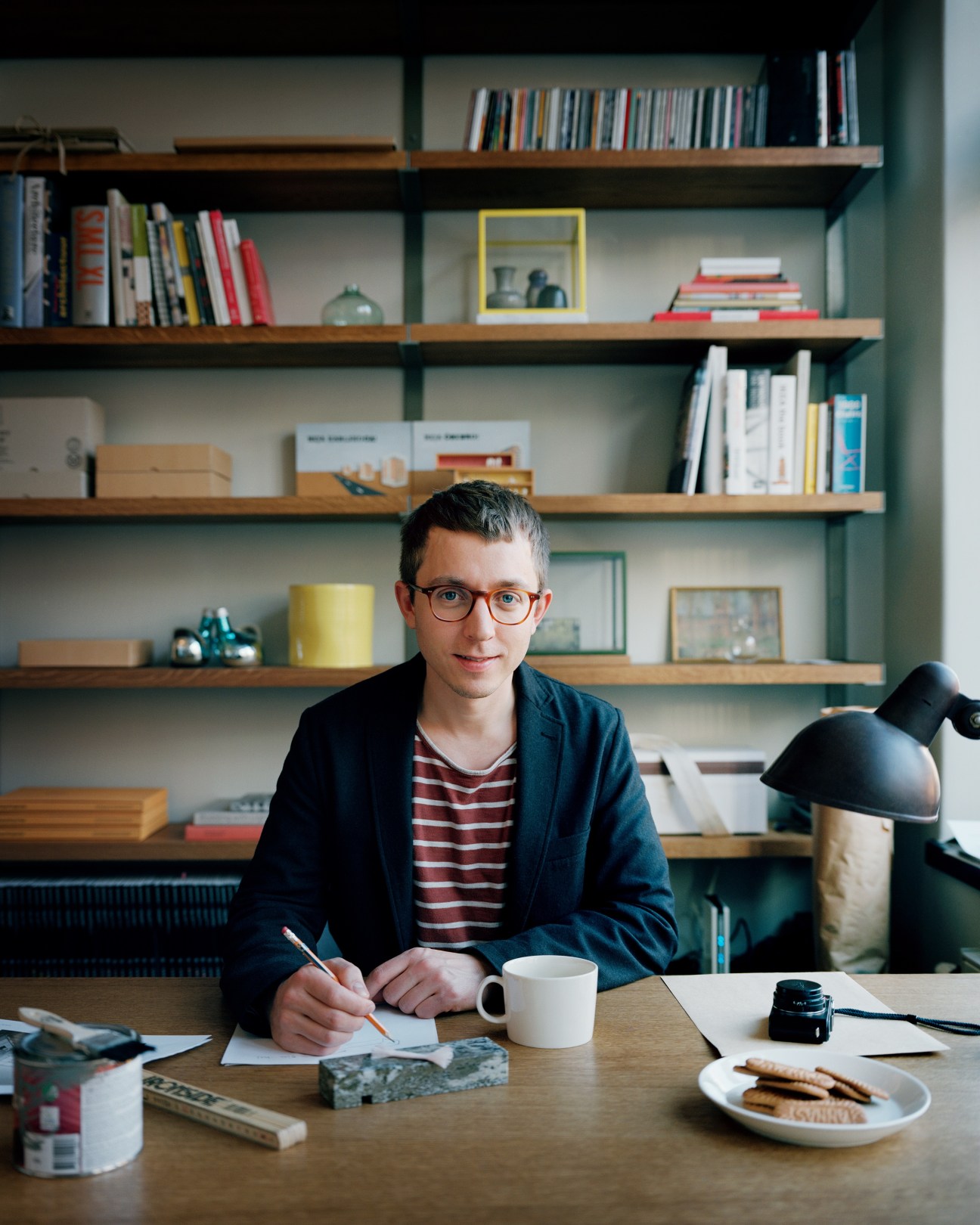Architect Andreas Martin-Löf sitting at his desk in his home office, writing.
