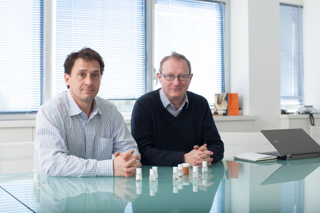 Fabien Durand and Bertrand de Preville seated at a table with perfume samples in a modern laboratory office.