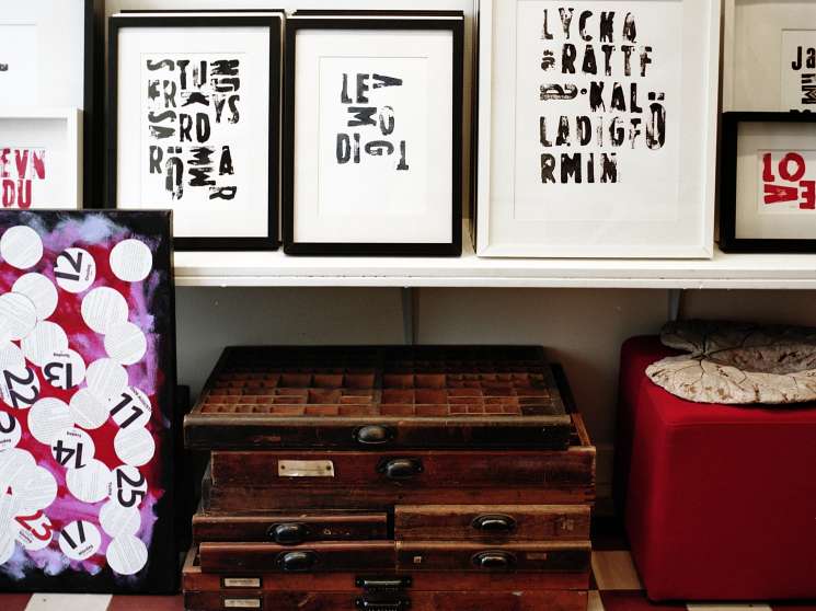 Framed graphic artworks and vintage suitcases displayed in Anna Lena Mayor Ekeblad's shop.
