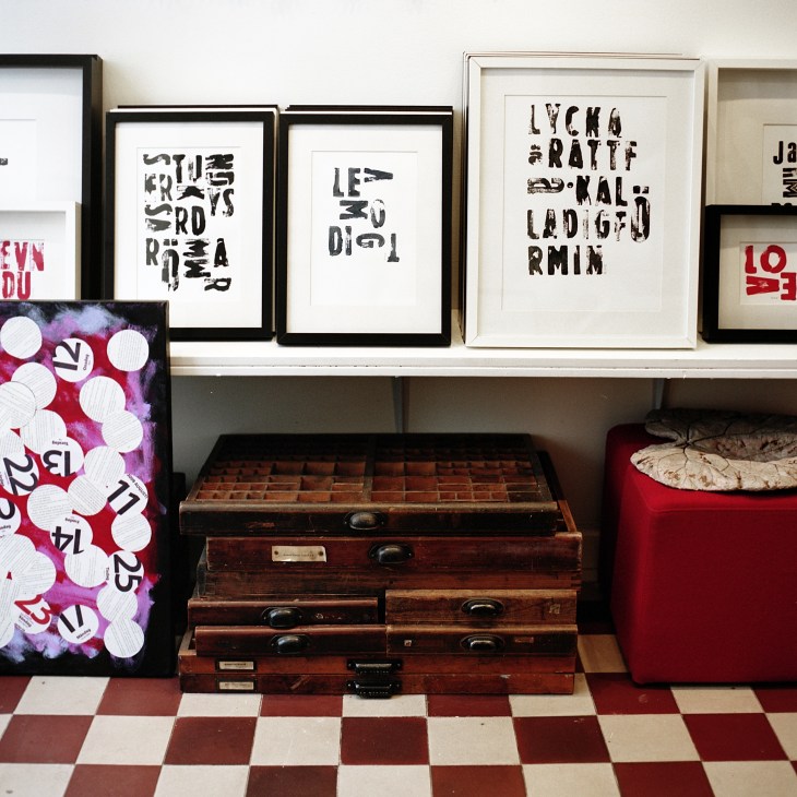 Framed graphic artworks and vintage suitcases displayed in Anna Lena Mayor Ekeblad's shop.