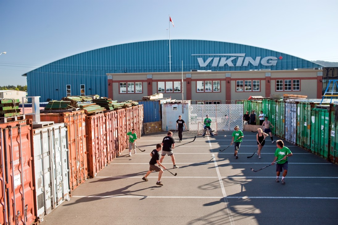 Viking Air employees play street hockey on a court made from shipping containers outside the factory.