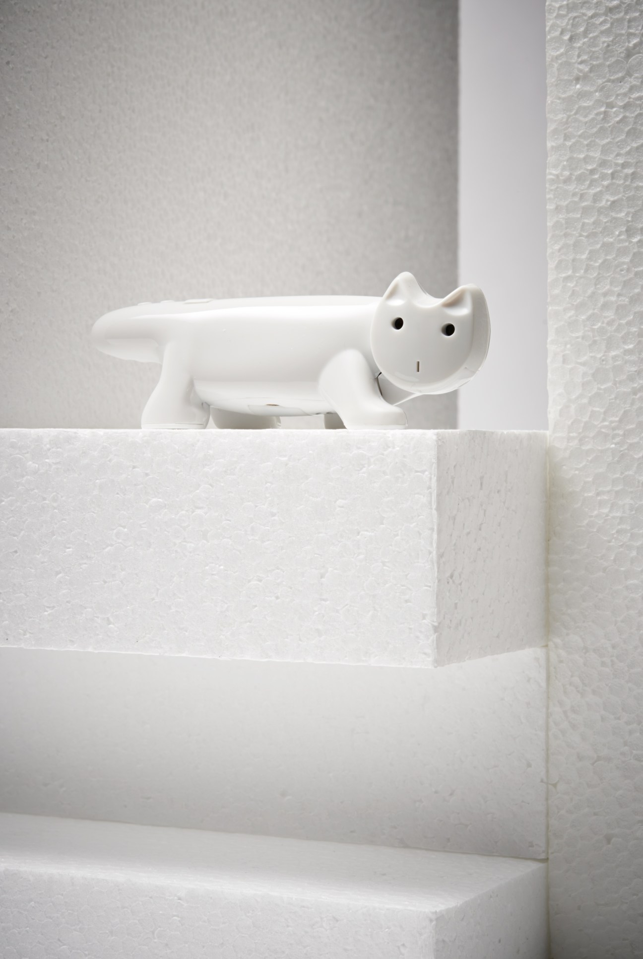 White ceramic cat-shaped camera by Superheadz on a white stone shelf.