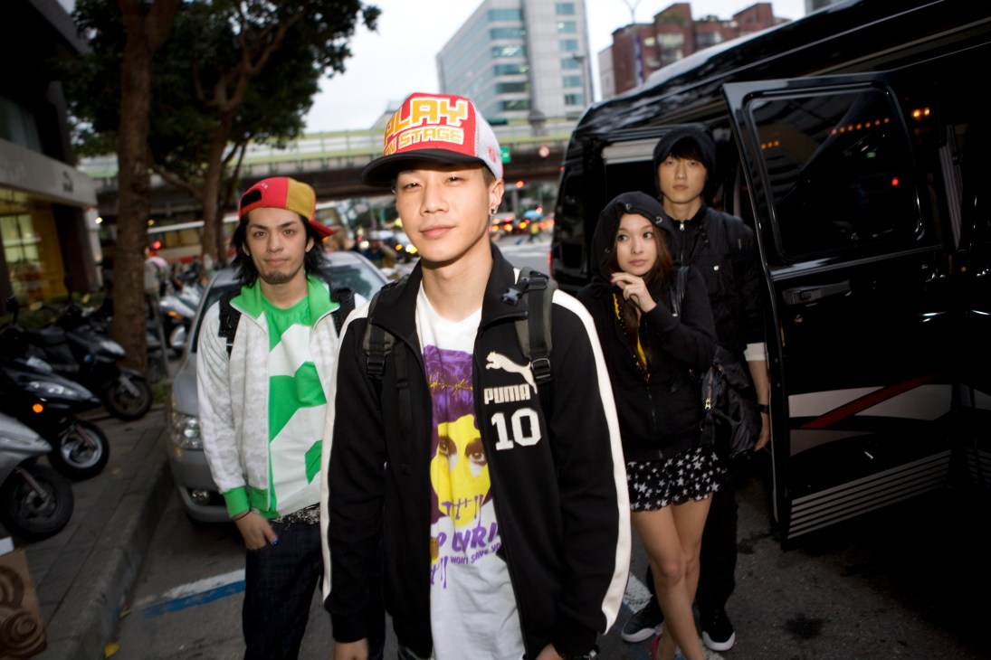 Hip-hop group Da Mouth disembarks from a black van on a Taipei street.