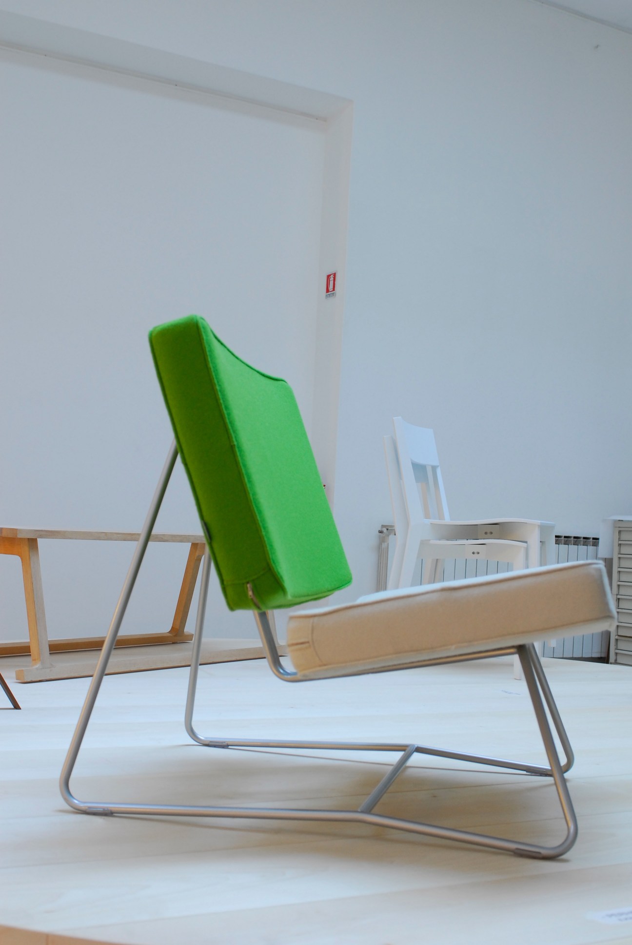 Perho chair by Ilkka Suppanen for E&Y with bright green upholstered back and natural wood armrest on metal frame.