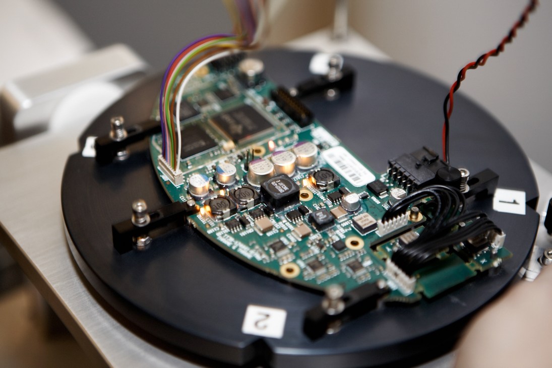 Close-up of Sailor 250 antenna circuit board with colorful wires and electronic components during calibration testing.