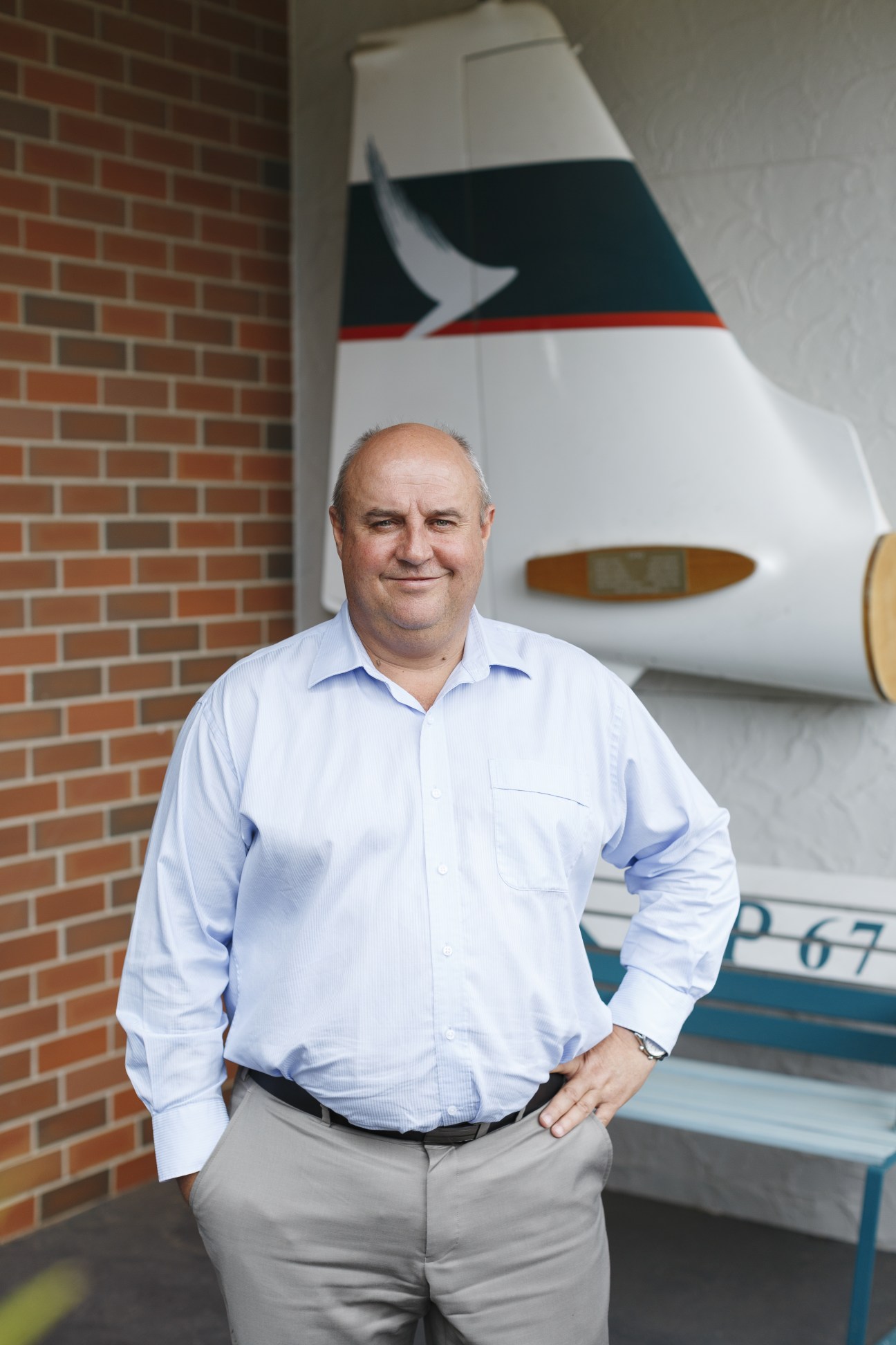 Pine Pienaar, CEO of FTA since 2008, stands in front of a Qantas aircraft tail in a hangar.