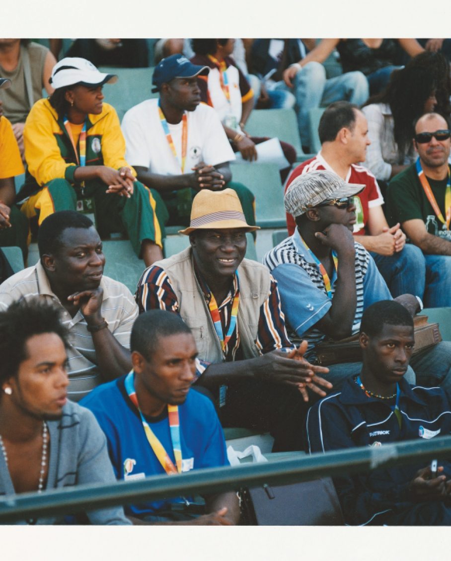 Guinea Bissau supporters sitting in stadium bleachers watching the Jogos da Lusofonia opening ceremony.
